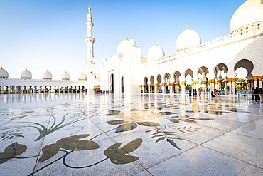 The domes and minarets of Abu Dhabi's Grand Mosque viewed across the large marble tiled central courtyard, Abu Dhabi, United Arab Emirates, Middle East