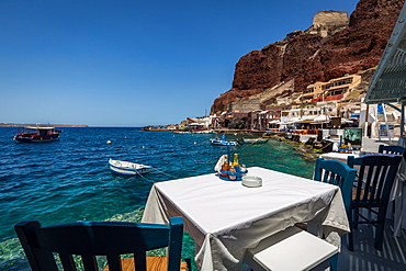 A table with a view at one of the seafood restaurants in Ammoudi Bay (Amoudi) at the bottom of steps below Oia, Santorini, Cyclades, Greek Islands, Greece, Europe