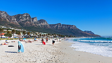 Skimboarders waiting for a wave on a sunny day at Camps Bay beach, Cape Town, Western Cape, South Africa, africa