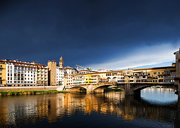 Ponte Vecchio reflecting in the Arno rRver against a dark blue stormy sky, Florence, UNESCO World Heritage Site, Tuscany, Italy, Europe