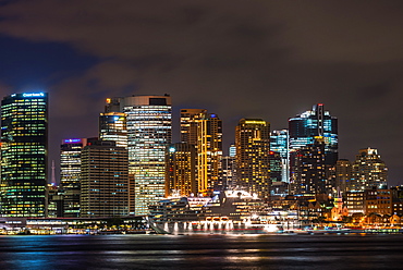 Large cruise ship docked at International Terminal in Sydney harbour after dark with city skyline, Sydney, New South Wales, Australia, Pacific