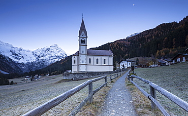 Church of Trafoi during frozen twilight with moon in the sky, Trafoi, Stelvio National Park, Alto Adige-Sudtirol, Italy, Europe