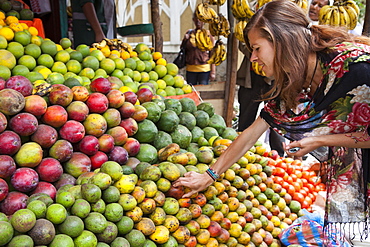 A VSO volunteer buying fresh fruit from a fruit stall on the side of the road in Addis Ababa, Ethiopia, Africa