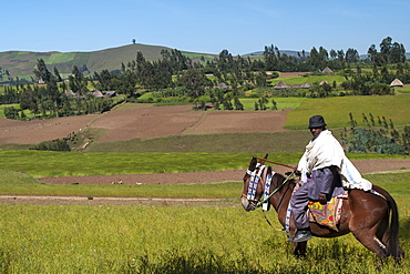 A man on horseback with a beautiful view of the rolling hills of rural Ethiopia, Africa