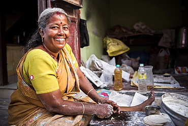 Portrait of an Indian woman making chapati in Fort Kochi (Cochin), Kerala, India, Asia