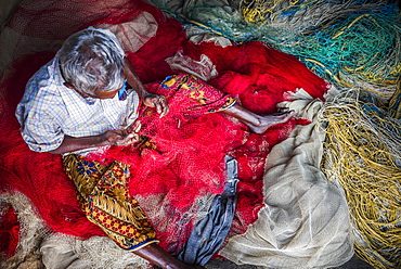 Fisherman mending net at Kappil Beach, Varkala, Kerala, India, Asia