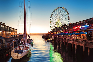 Sunset over mountains with Seattle Great Wheel on Pier 57 in the foreground. Seattle, Washington State, United States of America, North America