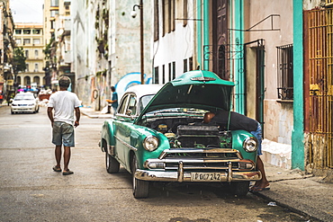 Local fixing his broken down American vintage car, La Habana (Havana), Cuba, West Indies, Caribbean, Central America