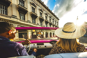 Tourist enjoying classic car ride at sunset in La Habana (Havana), Cuba, West Indies, Caribbean, Central America