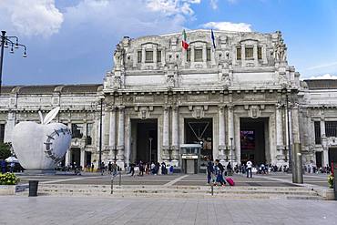 Milan Railway station facade with artwork of The Reintegraded Apple sculpture outside Milano Centrale at Piazza Duca dAosta, Milan, Lombardy, Italy, Europe