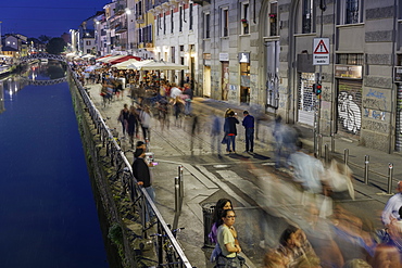 Navigli district at night with crowd on the banks of Naviglio Grande Canal, Milan, Lombardy, Italy, Europe