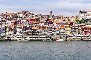 View across the Douro River to Ribeira traditional waterfront houses and moored tourist ships, UNESCO World Heritage Site, Porto, Portugal, Europe