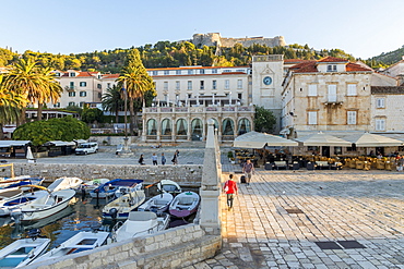 The main square (Trg Svetog Stjepana) of Hvar Town with view to the Spanish Fortress in the background at first sunlight, Hvar, Croatia, Europe