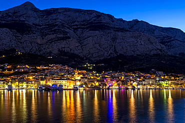 Cityscape of Makarska with Biokovo mountain range in the background at dawn, Makarska, Croatia, Europe