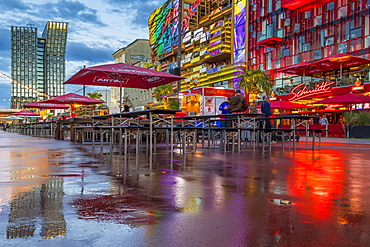 Reflections of the Dancing Towers (Tanzende Tuerme) and the illuminated buildings at the Spielbudenplatz on the wet ground, Hamburg, Germany, Europe