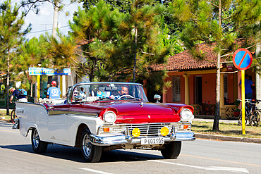 Red and white convertible vintage taxi on main road in Vinales, UNESCO World Heritage Site, Cuba, West Indies, Caribbean, Central America