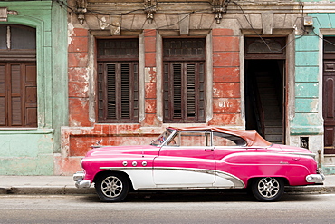 A pink and white vintage American convertible car parked on a street in Havana, Cuba, West Indies, Caribbean, Central America