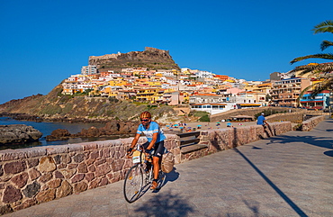 Cyclist on waterfront in Castelsardo, Sardinia, Italy, Europe