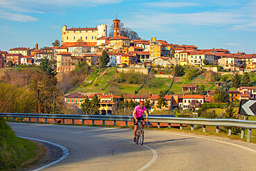 Cyclist leaving Cortanze, Piedmont, Italy, Europe