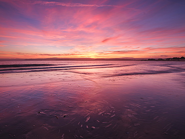 Really strong afterglow and interesting wispy clouds, reflected in the sea at Exmouth, Devon, England, United Kingdom, Europe