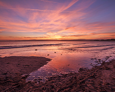 Really strong afterglow and interesting wispy clouds, reflected in the sea at Exmouth, Devon, England, United Kingdom, Europe