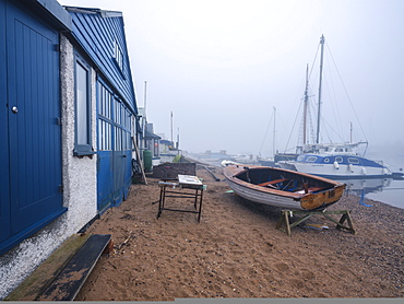 Misty scene with boats on the shoreline near the boatyard and sailmaker on a creek in Exmouth, Devon, England, United Kingdom, Europe