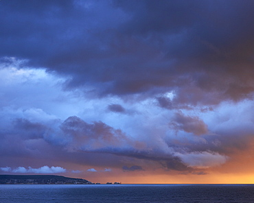 Dramatic sunset storm lighting and clouds over The Needles on the Isle of Wight, viewed from Milford-on-Sea, Hampshire, England, United Kingdom, Europe