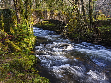 Water flows under Buckland Bridge as it joins the River Dart near Newbridge, Dartmoor National Park, Ashburton, Devon, England, United Kingdom, Europe