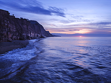 Sun peeps below a cloud bank at Sidmouth, Devon, England, United Kingdom, Europe