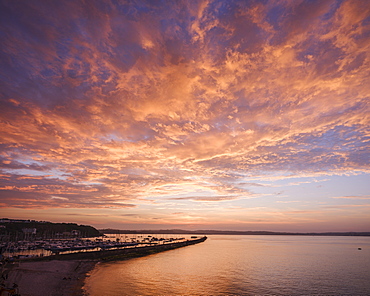 Colourful sunset view of Breakwater Beach and the harbour wall of Brixham, Devon, England, United Kingdom, Europe