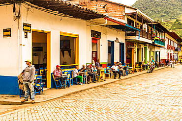 Local people socialising on the main square, with its preserved, colourful, colonial buildings, Jardin, Colombia, South America