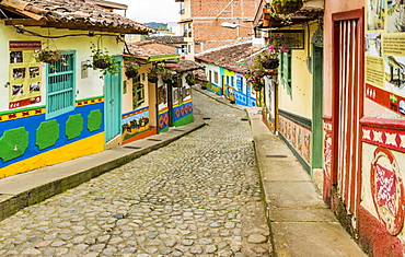 A typically colourful street with buildings covered in traditional local tiles in the picturesque town of Guatape, Colombia, South America