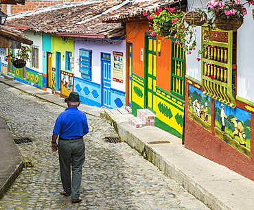 A typically colourful street with buildings covered in traditional local tiles in the picturesque town of Guatape, Colombia, South America