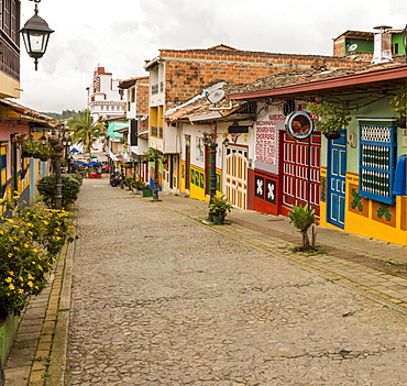 A typically colourful street with buildings covered in traditional local tiles in the picturesque town of Guatape, Colombia, South America