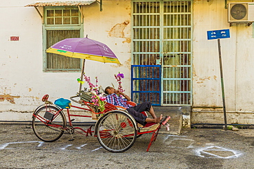 Local rickshaw (tuk tuk) driver in George Town, Penang Island, Malaysia, Southeast Asia, Asia