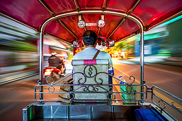 Speeding Tuk Tuk driving throught the streets of Bangkok at night, Bangkpok Thailand