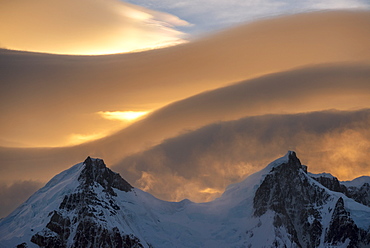 Lenticular clouds above snow covered mountain range, El Chalten, Patagonia, Argentina, South America