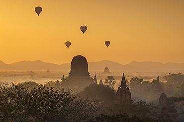 Atmospheric sunrise with ballons over Stupas in Bagan (Pagan), Bagan, Myanmar (Burma), Asia