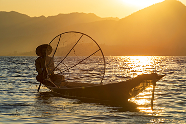 Intha leg rowing fisherman at sunset on Inle Lake, Shan State, Myanmar (Burma), Asia