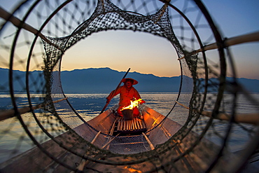 Intha leg rowing fisherman viewed through net on Inle Lake, Shan State, Myanmar (Burma), Asia