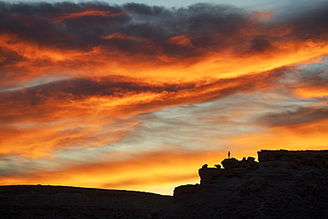 Lone figure on hill watching dramatic sunset, Ait Benhaddou, Morocco, North Africa, Africa