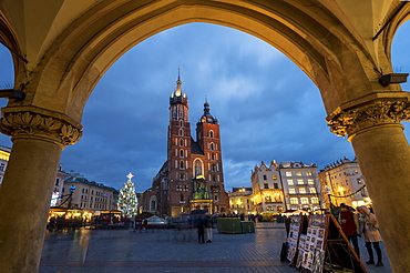 Saint Mary's Basilica at night framed with arch stonework in Market Square, UNESCO World Heritage Site, Krakow, Poland, Europe