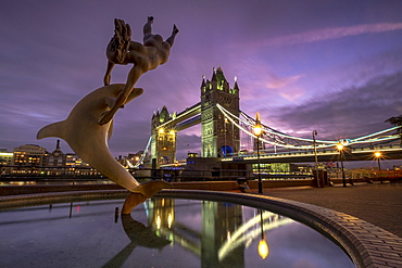 Tower Bridge with the Girl and Dolphin statue at St. Katherines Dock at night, London, England, United Kingdom, Europe