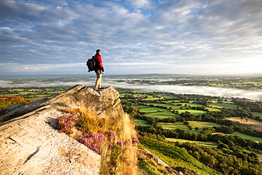 Hiker on rock above Cheshire Plains, Cloudside near Congleton, Cheshire, England, United Kingdom, Europe