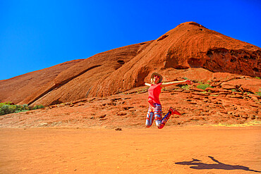 Tourist woman jumping enjoying the Lungkata walk connecting Kuniya walk to Mala carpark at Uluru (Ayers Rock), Uluru-Kata Tjuta National Park, UNESCO World Heritage Site, Northern Territory, Australia, Pacific