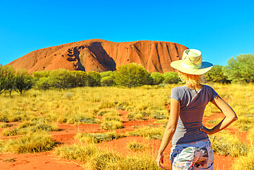 Tourist woman in hat looks at Uluru (Ayers Rock) in the dry season, Uluru-Kata Tjuta National Park, UNESCO World Heritage Site, Northern Territory, Australia, Pacific