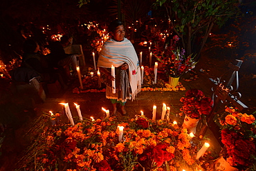 Zapotec woman holding candle among graves adorned with marigolds, Atzompa, Oaxaca, Mexico, North America