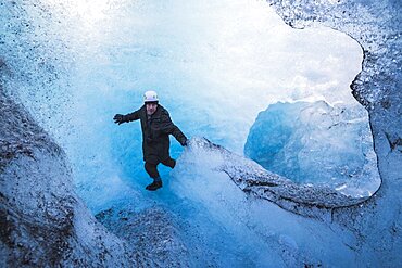 Tourist exploring an ice cave on adventure vacation at Breidamerkurjokull Glacier, Vatnajokull Ice Cap, Iceland, Europe