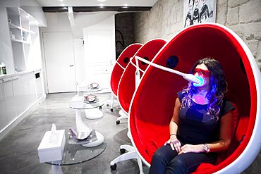 Reportage in a smile bar in Paris, France. Teeth whitening involves applying a whitening paste using a special mouthpiece, then exposing the teeth to a LED lamp which sets off the whitening process.