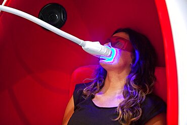 Reportage in a smile bar in Paris, France. Teeth whitening involves applying a whitening paste using a special mouthpiece, then exposing the teeth to a LED lamp which sets off the whitening process.